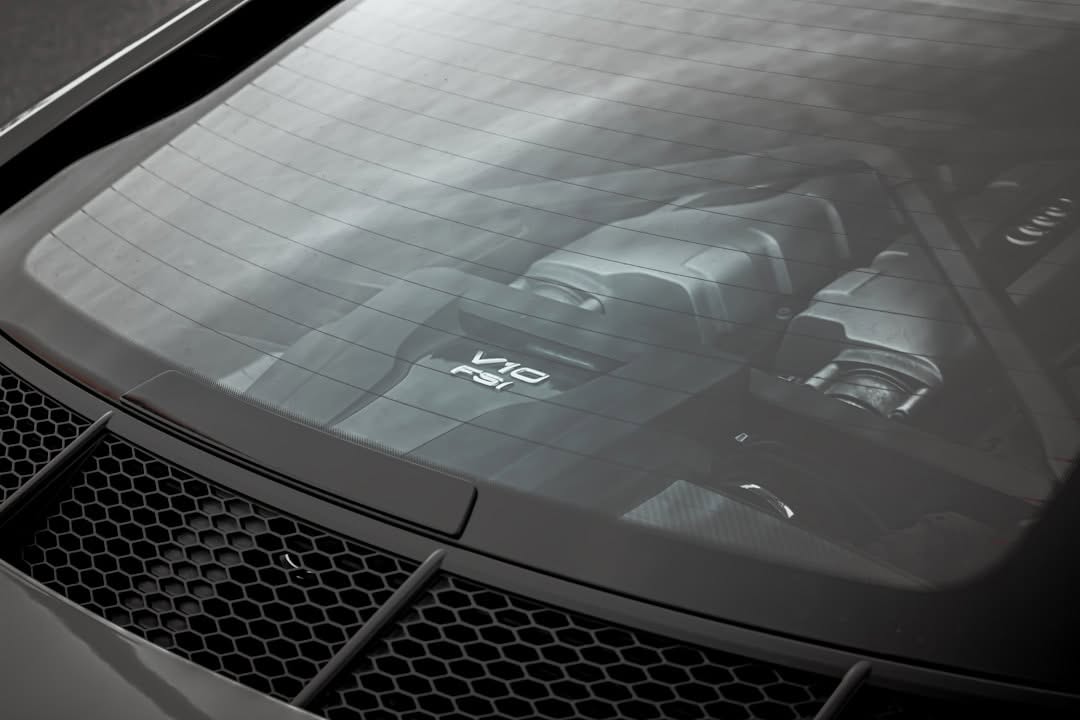 Close-up view of a car’s rear window showing the V10 FSI engine compartment, with engine details visible through the glass.