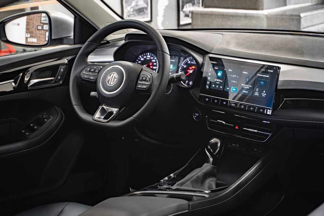 Interior of a modern car featuring a digital dashboard, touchscreen display, multifunction steering wheel, and automatic gear shift lever.